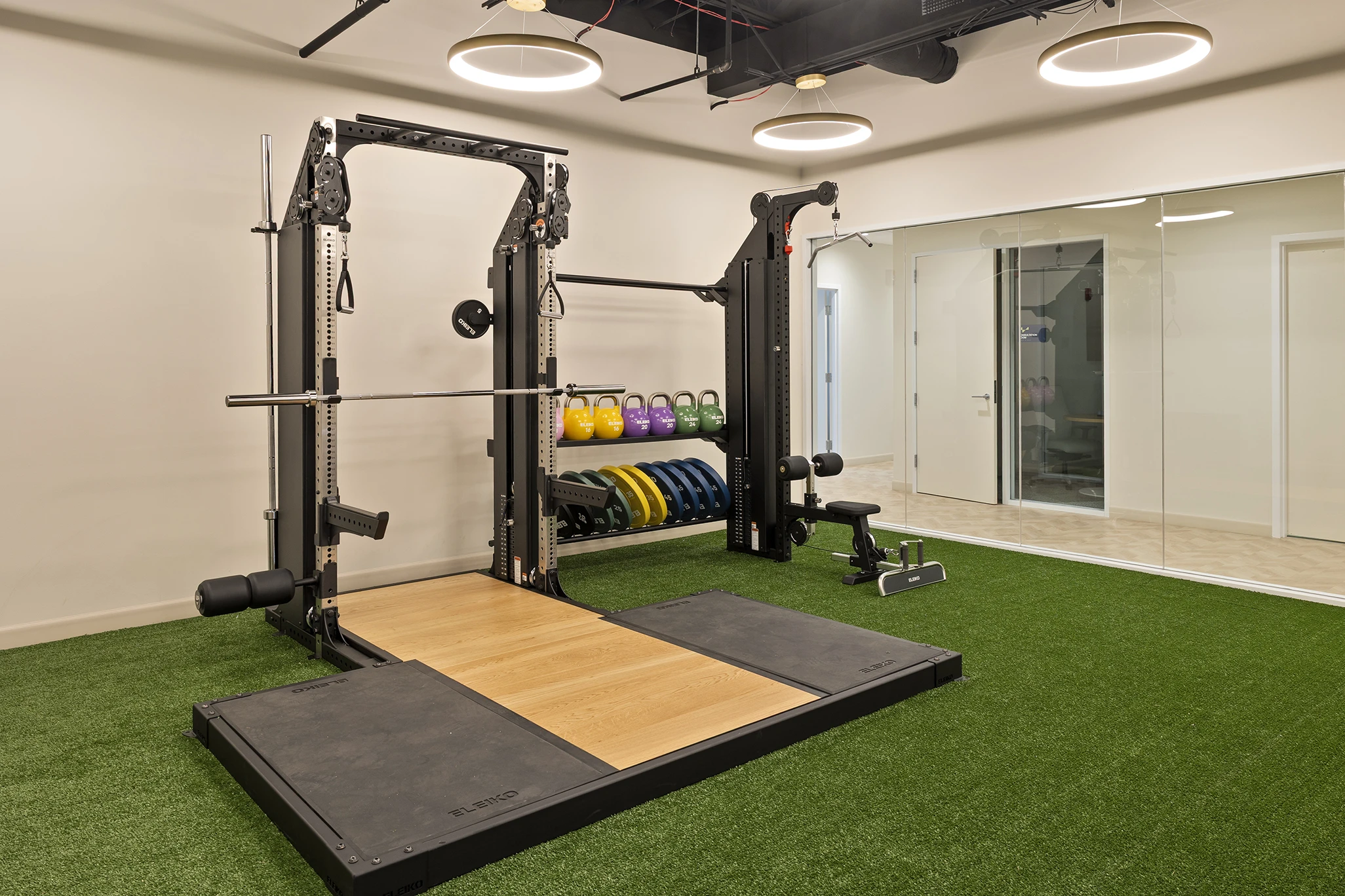 True Health Buffalo Grove in-office performance and fitness training area with equipment, kettlebells, and turf